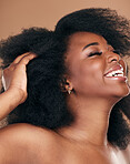 Happy, black woman or hair care for afro, natural beauty or cosmetics on a brown studio background. Growth, hairstyle or African model with wellness, aesthetic or texture with salon treatment or glow