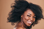 Portrait, hair care and black woman with beauty, afro and smile on a brown studio background. Cosmetics, person and African model with texture, shine and volume with aesthetic, wellness and glow