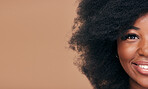 Portrait, hair and mockup with a model black woman in studio on a brown background for natural cosmetics. Half face, smile and haircare with a happy afro female person on space for shampoo treatment
