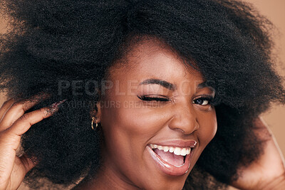 Buy stock photo Portrait, hair and wink with a natural black woman in studio on a brown background for organic cosmetics. Beauty, face and haircare with a happy young afro female person indoor for shampoo treatment