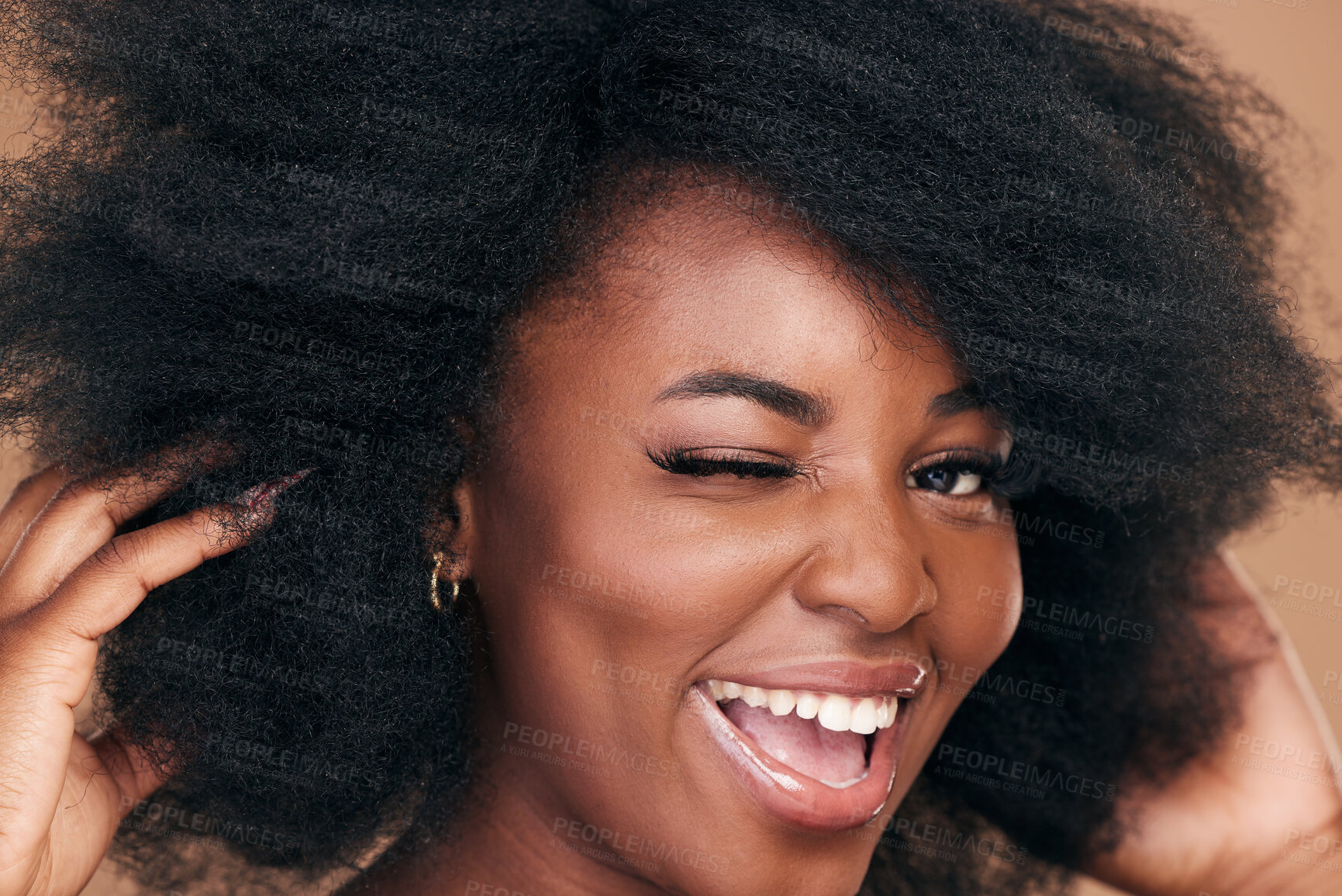 Buy stock photo Portrait, hair and wink with a natural black woman in studio on a brown background for organic cosmetics. Beauty, face and haircare with a happy young afro female person indoor for shampoo treatment