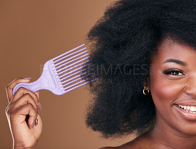 Buy stock photo Portrait, hair and comb with a natural black woman in studio on brown background for cosmetics. Face, smile and haircare with a happy young model brushing her afro after for shampoo treatment