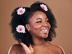 Hair care, flowers and black woman, afro and thinking in studio isolated on a brown background. Happy, floral cosmetics and natural African model in organic salon treatment, wellness and hairstyle