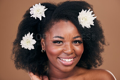 Buy stock photo Afro, hair care or portrait of black woman with flowers, beauty or smile on a brown studio background. Hairstyle, floral or happy African model with shine and volume with aesthetic, wellness or glow