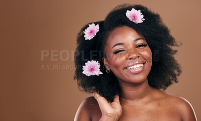 Buy stock photo Afro hair, mockup or portrait of black woman with flowers, beauty or smile on a brown studio background. Hairstyle, space or happy African model with aesthetic, wellness or glow with floral plants