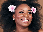 Hair care, flowers and black woman in afro, thinking and beauty in studio isolated on brown background. Smile, floral hairstyle cosmetic and natural African model in organic salon skincare treatment
