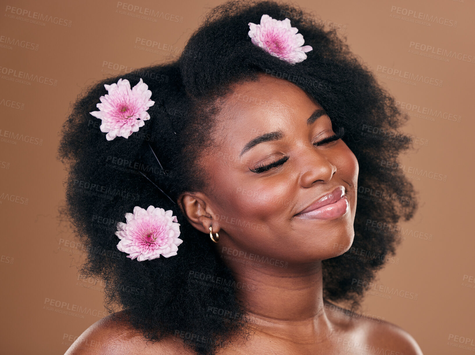 Buy stock photo Hair care, flowers and black woman, happy and beauty in studio isolated on a brown background. Smile, floral afro cosmetics or natural African model in organic salon treatment, wellness and hairstyle