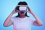 Woman, VR technology and surprise in studio for user experience, digital world and future multimedia game on blue background. Virtual reality glasses, metaverse and wow for innovation of UX gaming