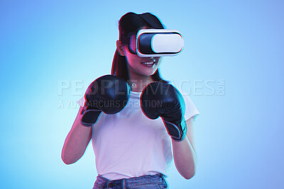 Buy stock photo Virtual reality, metaverse and a gamer woman boxing on a blue background in studio for fitness or exercise. AI, sports and training with a young female boxer playing an online fantasy game for health