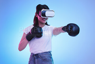 Buy stock photo AI, virtual reality and a gamer woman boxing on a blue background in studio for fitness or exercise. Metaverse, sports and training with a young female boxer playing an online fantasy game for health
