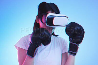 Buy stock photo AI, metaverse and a sports woman boxing on a blue background in studio for fitness or exercise. Virtual reality, gamer and training with a young female boxer playing an online fantasy game for health