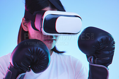 Buy stock photo Sports, metaverse and a gamer woman boxing on a blue background in studio for fitness or exercise. Virtual reality, ai and training with a young female boxer playing an online fantasy game for health
