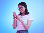 Phone, typing an Asian woman on social media with mobile app, internet or web isolated in a studio blue background. Connection, cellphone and young female speaking with smile for communication