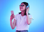 Woman, student and phone with headphones listening to music, techno streaming and radio on blue background. Person, gen z or youth audio, electronics and mobile subscription in neon light and studio