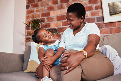 Buy stock photo Happy, relax and a mother on the sofa with a child for conversation, bonding and family in a house. Smile, care and an African mom or woman with a girl kid on the living room couch for talking