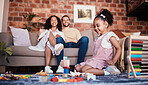 Happy, playing and a child with building blocks and parents for relax, education and learning in a house. Smile, playful and a girl kid with toys and a mother and father in a living room as family