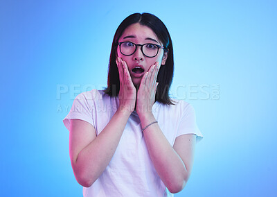 Buy stock photo Surprise, open mouth and face of Asian woman with wow expression or shocked for drama, deal and promotion. Omg, wtf and portrait of person with discount emoji isolated in a studio blue background