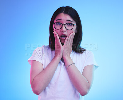 Buy stock photo Surprise, drama and face of Asian woman with fear expression, shocked or open mouth for crisis and fail. Omg, wtf and portrait of person with scared emoji isolated in a studio blue background