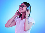 Young woman, student and headphones for listening, audio streaming and happy subscription on blue background. Gen z, youth or person smile for mental health music or podcast on electronics in studio
