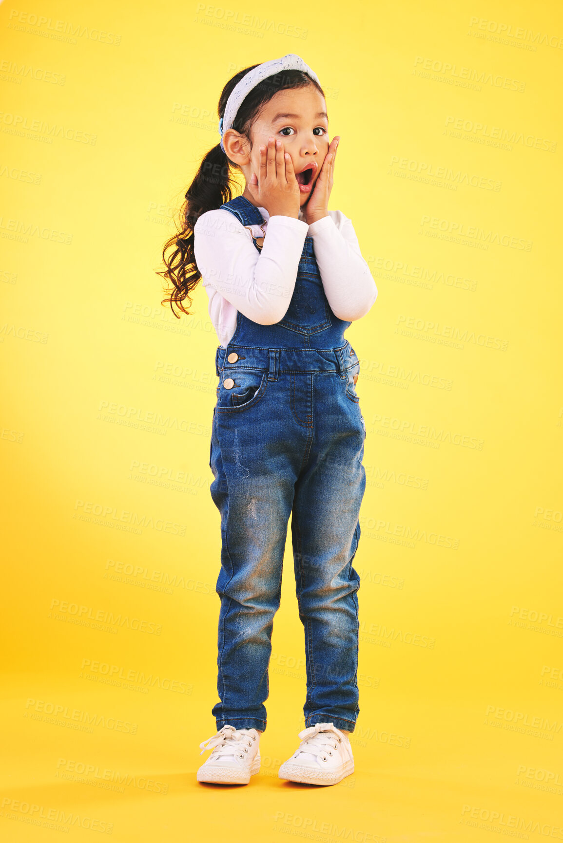 Buy stock photo Children, fashion and hands on face of girl child in studio with deal, sale or giveaway promo on yellow background. Wow, surprise and open mouth kid with emoji for news, announcement or sign up info