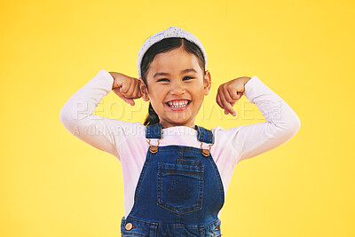 Buy stock photo Smile, portrait and girl child with arm flex in studio for confidence, strong and power on yellow background. Happy, face and excited kid with bicep strength, pose or empower, positive or growth sign