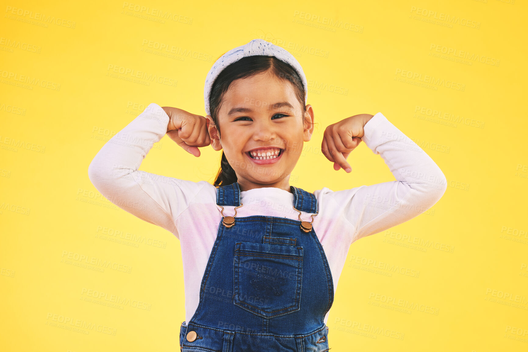 Buy stock photo Smile, portrait and girl child with arm flex in studio for confidence, strong and power on yellow background. Happy, face and excited kid with bicep strength, pose or empower, positive or growth sign