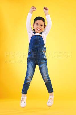Buy stock photo Portrait, kids and jump with a winner girl on a yellow background in celebration of success or victory. Children, goals and motivation with a young kid cheering for an award or achievement in studio