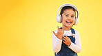Portrait, happy and girl child with music headphones in studio for streaming subscription on yellow background. Face, smile and kid with headset for podcast, radio or audio, track and album playlist