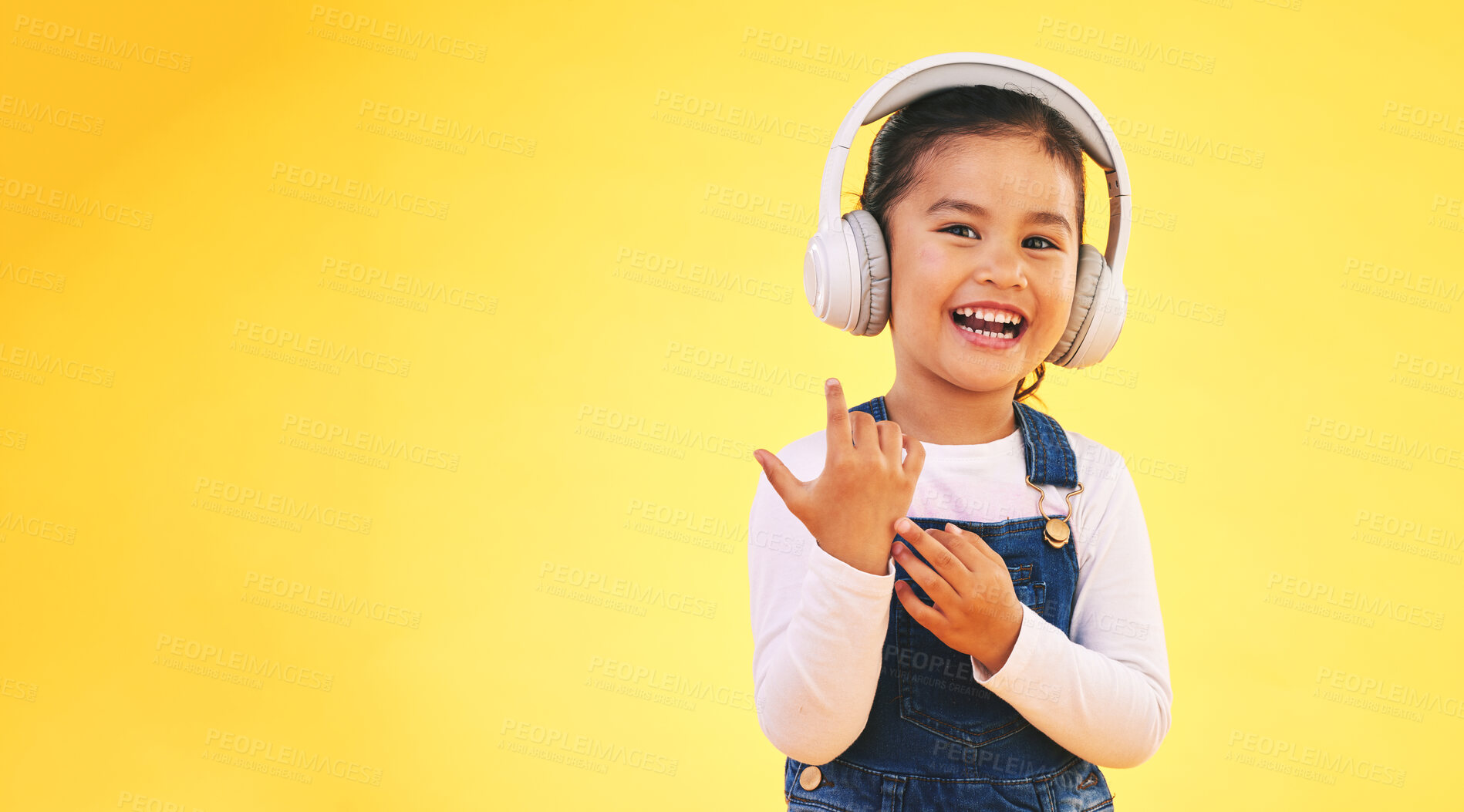 Buy stock photo Portrait, happy and girl child with music headphones in studio for streaming subscription on yellow background. Face, smile and kid with headset for podcast, radio or audio, track and album playlist
