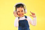 Girl child, studio portrait and headphones with smile, listening or audio tech by yellow background. Happy female kid, sound and music with streaming subscription, radio and hearing in trendy fashion