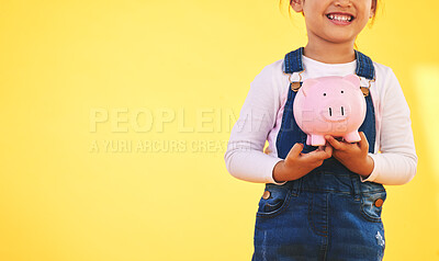 Buy stock photo Girl kid, piggy bank and saving in studio with smile, mockup space and excited by yellow background. Young female child, money box and start investment for promo, financial knowledge or future goal