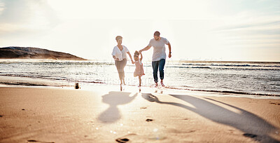 Buy stock photo Beach, sunset and child with her mother and father on a vacation, adventure or holiday together for bonding. Travel, having fun and girl kid walking with parents on the sand by ocean on weekend trip.