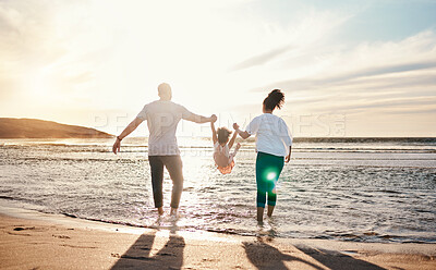 Buy stock photo Dad, mom and swing girl on beach, holiday and vacation in Florida for bonding, adventure and family together in waves. Mother, father and child at sunset in ocean, sea or playing in water for fun