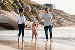Family, beach and holding hands, parents and child with travel and bonding, love and walking together outdoor. Vacation, ocean and happy people in nature, man and woman with kid, sun and adventure 
