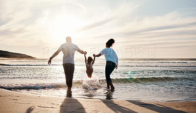 Buy stock photo Mom, dad and swing girl on beach, holiday and vacation in Florida for bonding, adventure and family together in waves. Mother, father and child at sunset in ocean, sea or playing in water for fun