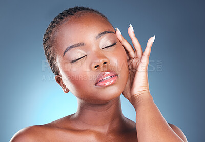 Buy stock photo Skin, beauty and face of a black woman with makeup, dermatology and glow. Headshot of African person on a studio blue background with cosmetics and facial self care with hand for soft touch and shine