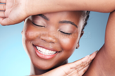 Buy stock photo Beauty, skincare and black woman closeup of armpit and smile, cosmetics and makeup in studio. Wellness, happy African model on blue background and skin glow with shine from dermatology treatment