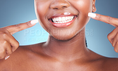 Buy stock photo Happy woman, teeth and pointing in dental cleaning, hygiene or treatment against a blue studio background. Closeup of female person mouth in tooth whitening, oral and gum care with big smile