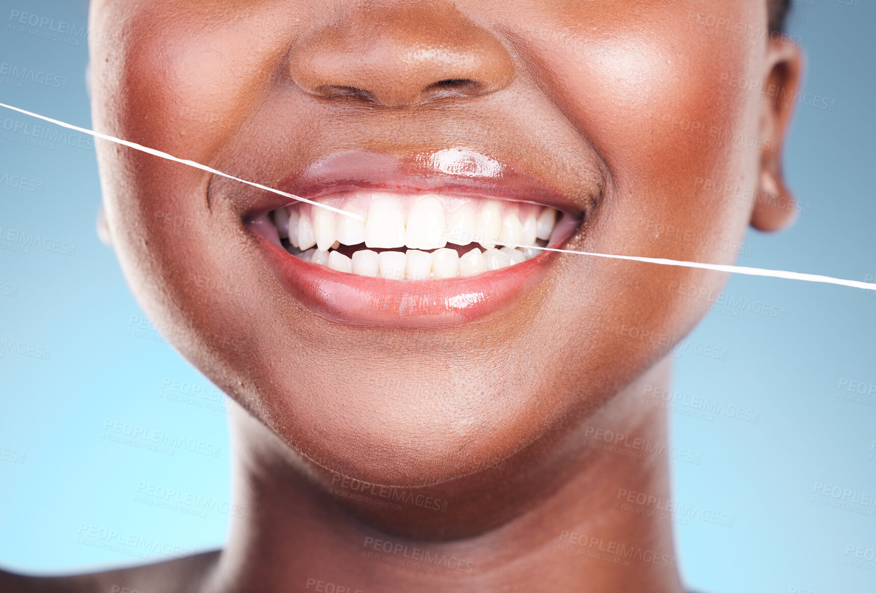 Buy stock photo Happy woman, teeth and dental floss in cleaning, hygiene or cosmetics against a blue studio background. Closeup of female person with big smile flossing in tooth whitening for oral, mouth or gum care
