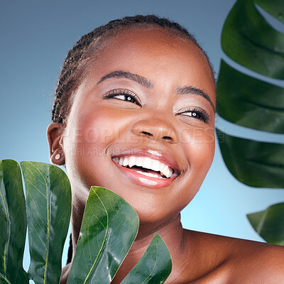 Buy stock photo Beauty face, leaf and black woman happiness for natural self care, cosmetics or sustainable product. Studio, plant and clean African person with monstera, eco friendly and skincare on blue background