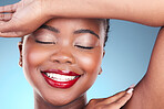 Happy, beauty and black woman with makeup, cosmetics and skincare on a blue studio background. Shine, African person or model with lip gloss, smile or dermatology with luxury, aesthetic or spa facial