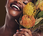 Smile, beauty and protea with the face of a black woman in studio on brown background for natural treatment. Skincare, plant or cosmetics and a young model indoor for aesthetic wellness with flowers