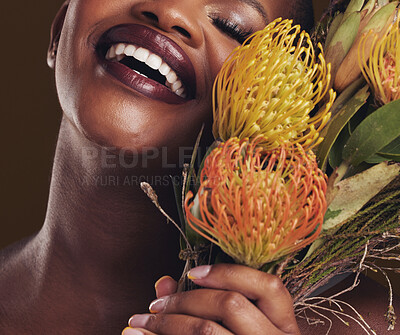 Buy stock photo Smile, beauty and protea with the face of a black woman in studio on brown background for natural treatment. Skincare, plant or cosmetics and a young model aesthetic wellness with eco flowers