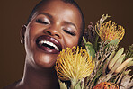 Skincare, face and plant with the face of a black woman in studio on brown background for natural treatment. Beauty, protea or cosmetics and a young model indoor for aesthetic wellness with flowers