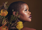 African woman, flowers and studio profile for beauty, wellness or thinking with vision by brown background. Girl, model and facial makeup for skin, sustainable cosmetics or idea for healthy aesthetic