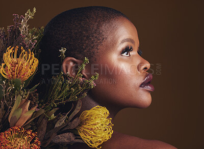 Buy stock photo African woman, flowers and studio profile for beauty, wellness or thinking with vision by brown background. Girl, model and facial makeup for skin, sustainable cosmetics or idea for healthy aesthetic