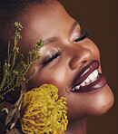 Face, beauty and protea with the smile of a black woman in studio on brown background for natural treatment. Happy, plant or cosmetics and a young model indoor for aesthetic wellness with flowers