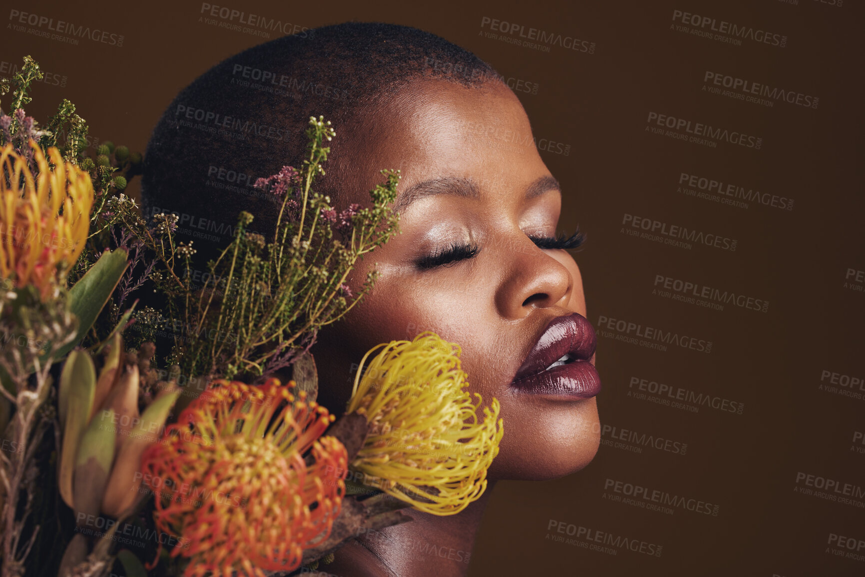 Buy stock photo Black woman, flowers and makeup in studio for beauty, wellness or thinking with protea by brown background. Girl, model and glow on facial skin, sustainable cosmetics and eyes closed for aesthetic