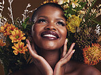 African woman, plants and ideas in studio with flowers for beauty, wellness or smile for glow by brown background. Girl, model and face for thinking, leaves or memory for cosmetics, skin or aesthetic