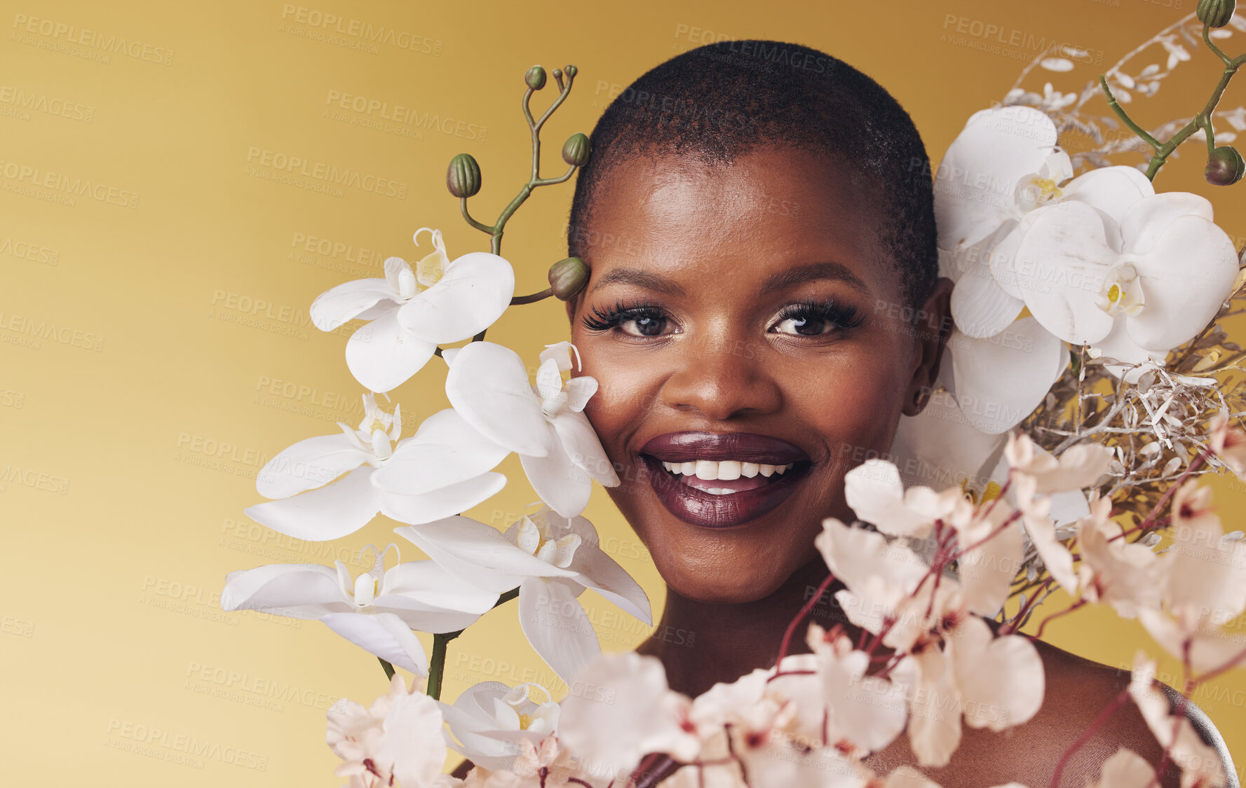 Buy stock photo Black woman, flowers and beauty with portrait, smile with makeup and natural cosmetics isolated on studio background. African model, orchid and nature, sustainable skincare and with facial and glow